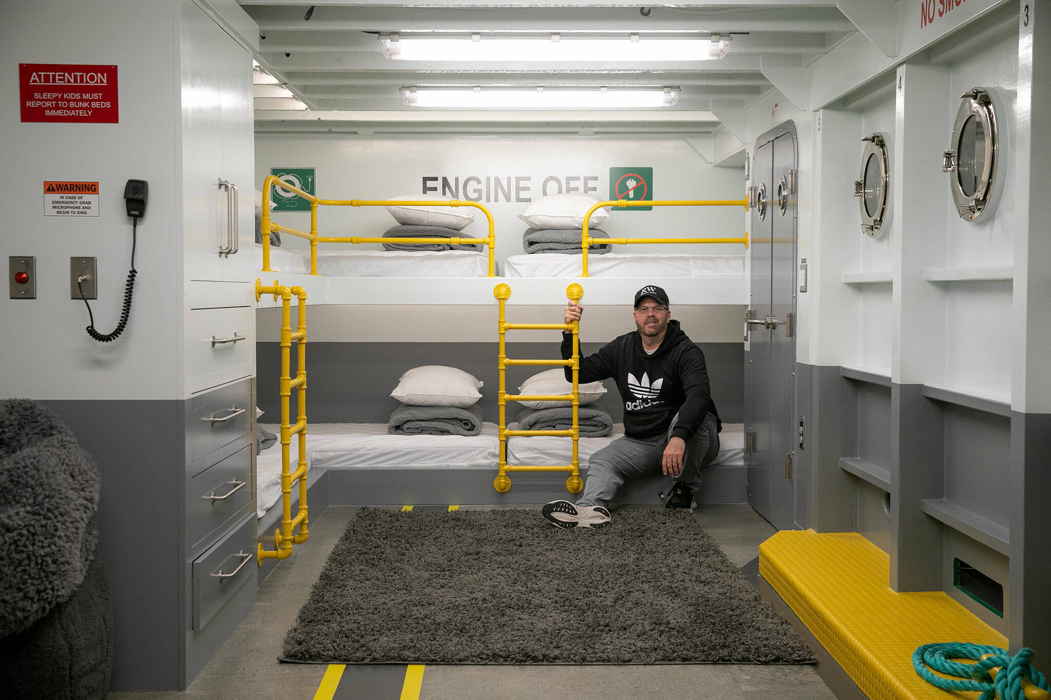 Homeowner Ryan Anderson sits on the bunk beds in the ferry quarters at Ferry Cove, the latest feature in the 5-bedroom waterfront vacation rental in Clinton. (Ryan Berry / The Herald)