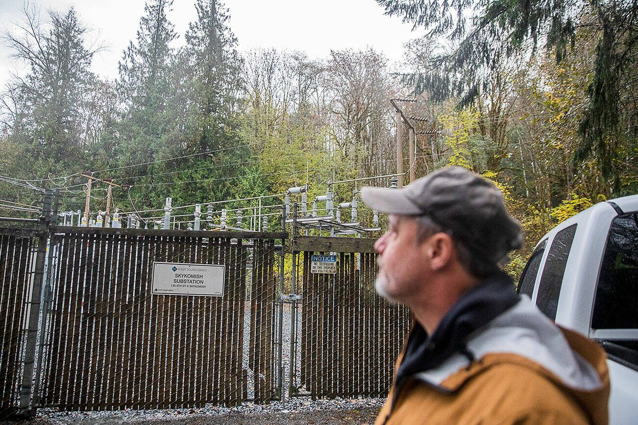 Vernon Streeter looks over the fence at the Skykomish Substation operated by Puget Sound Energy on Monday, Nov. 4, 2024 in Skykomish, Washington. (Olivia Vanni / The Herald)