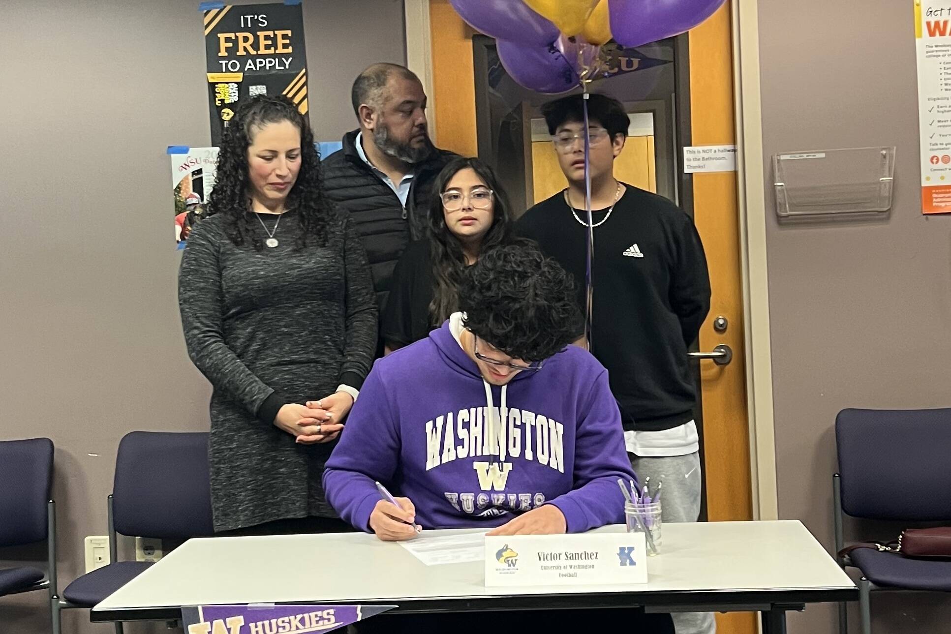 Victor Sanchez Hernandez Jr. signs his letter of intent to play football at the University of Washington on Dec. 4, 2024 at Kamiak High School. (Photo courtesy of Ezra Davis)